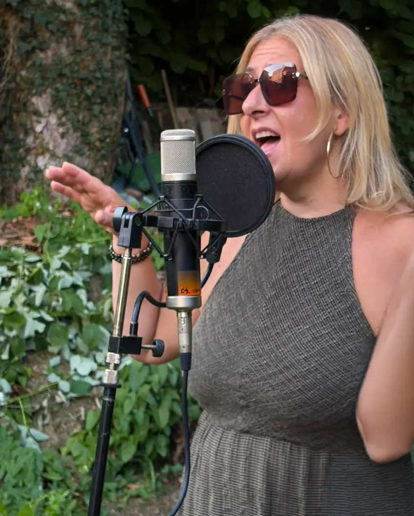Lucilla Pepe chante devant un microphone en extérieur